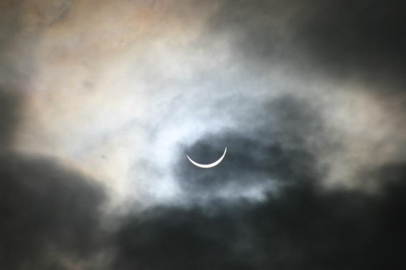 The partial solar eclipse, as glimpsed through breaking cloud cover.