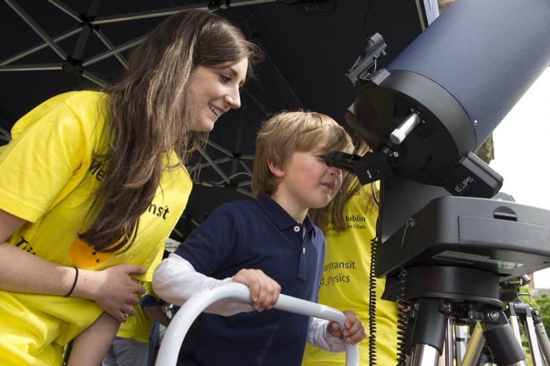 Laura Hayes, PhD Researcher in Trinity's School of Physics, helps one of the younger visitors focus in on Mercury's transit across the Sun.